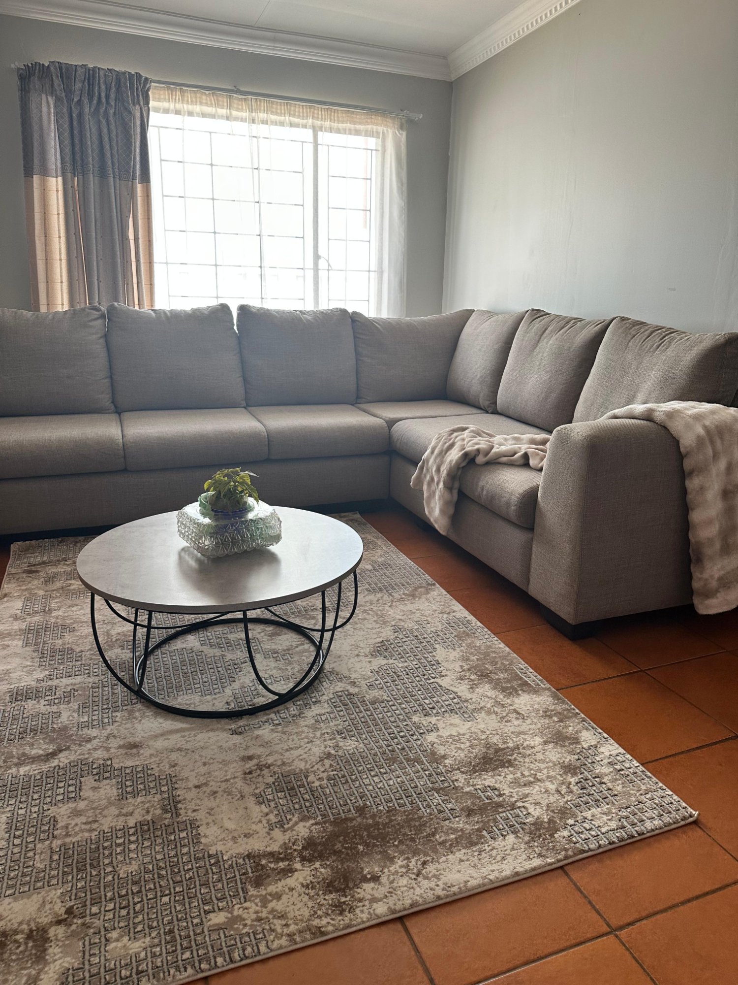 Spacious lounge at Dream & Drift with large L-shaped sectional sofa, coffee table and curtained windows