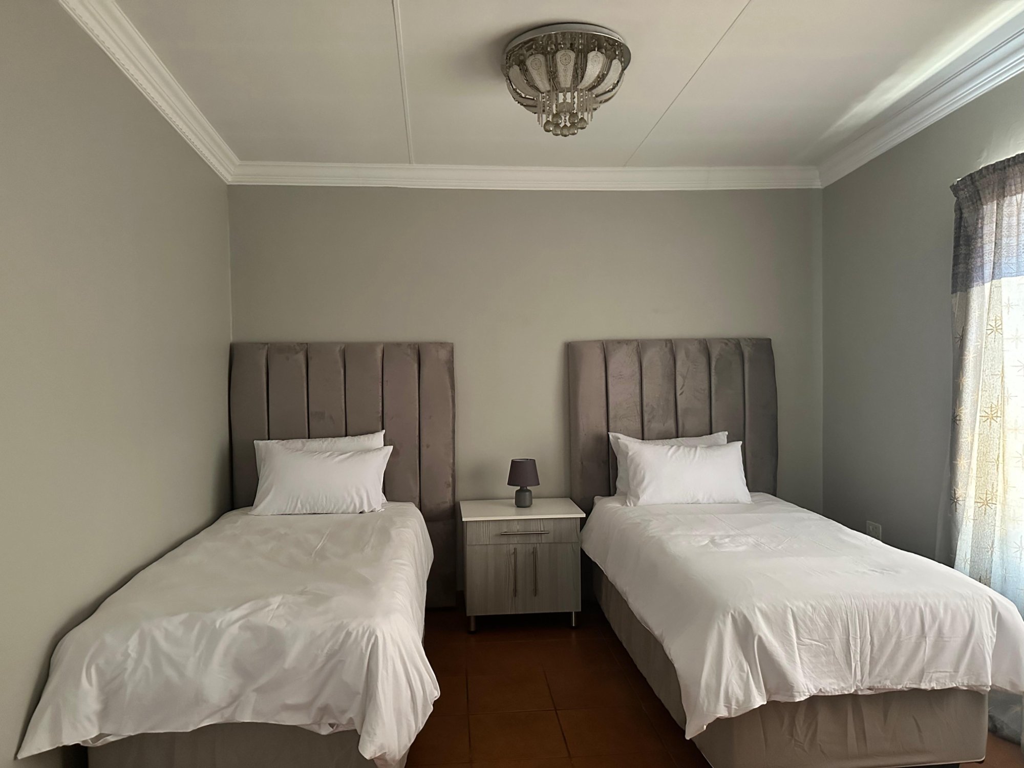 Twin bedroom with two single beds and crystal chandelier at Dream and Drift